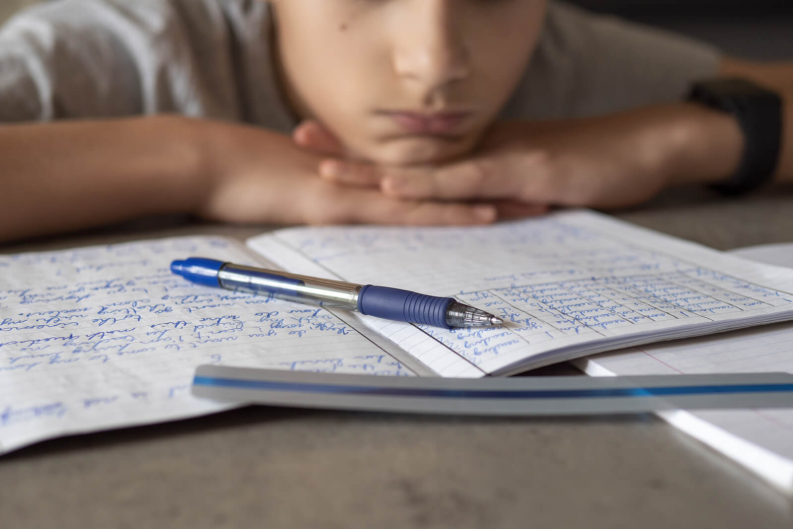 A child looking down at a testing booklet. Psychoeducational testing could be what your child needs. Contact us today.
