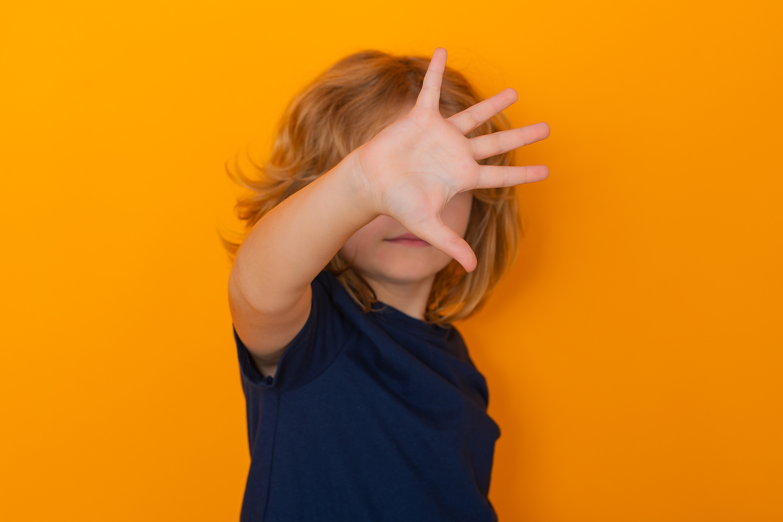Child makes a stop gesture on an orange background. ADHD testing in the San Francisco areas is just what your child needs to thrive! Learn more about ADHD testing here.