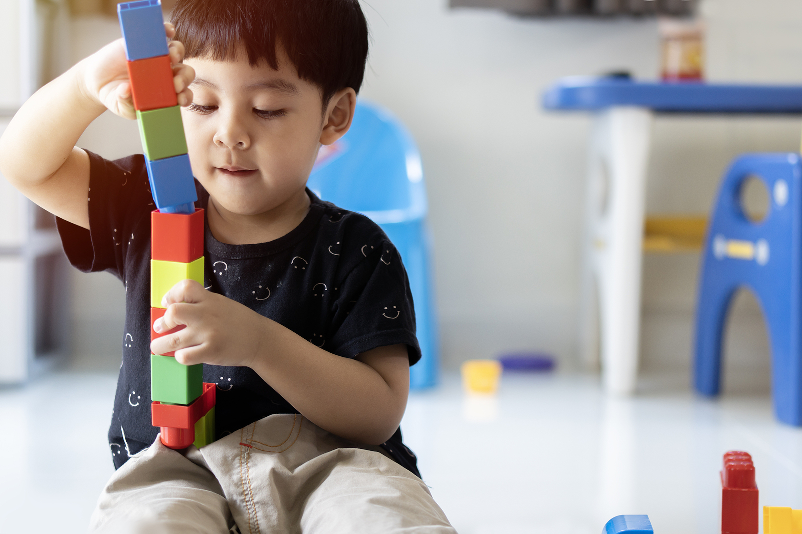 Young boy playing with creative toy blocks. A neurodevelopmental screening in Berkeley, CA can help your child. Learn all the benefits of autism, ADHD & dyslexia testing.