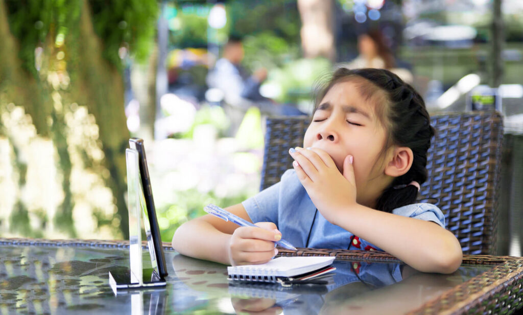 A young girl yawning while doing her homework. ADHD testing can be very beneficial for your children. Learn more about ADHD testing in San Francisco here.